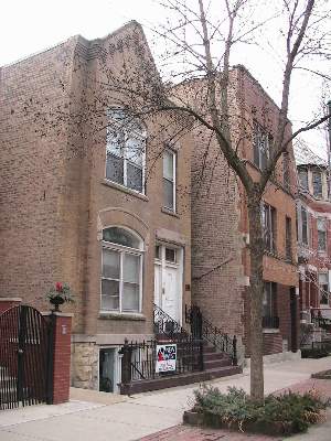 a front view of a building with large trees