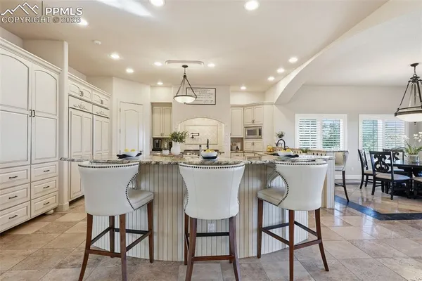 a kitchen with a dining table chairs and white cabinets