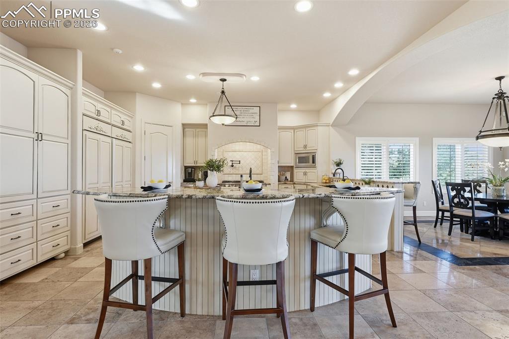 5039 Stonehill Road Colorado Springs, CO 80918 - Photo 13 of 50 a kitchen with a dining table chairs and white cabinets