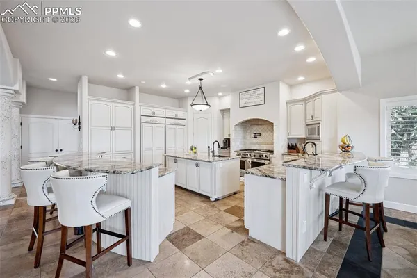 a kitchen with counter and chairs