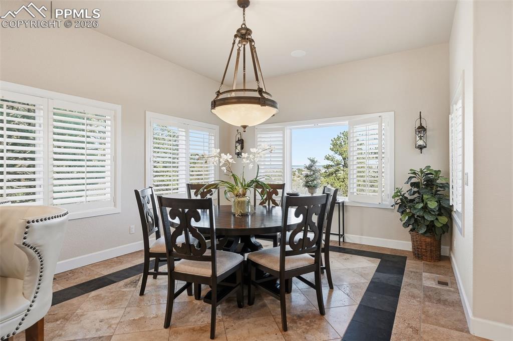5039 Stonehill Road Colorado Springs, CO 80918 - Photo 19 of 50 a view of a dining room with furniture window and wooden floor