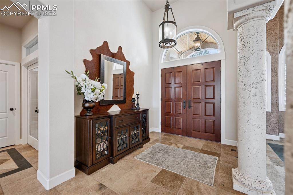 5039 Stonehill Road Colorado Springs, CO 80918 - Photo 6 of 50 a view of a hallway with wooden floor and a chandelier