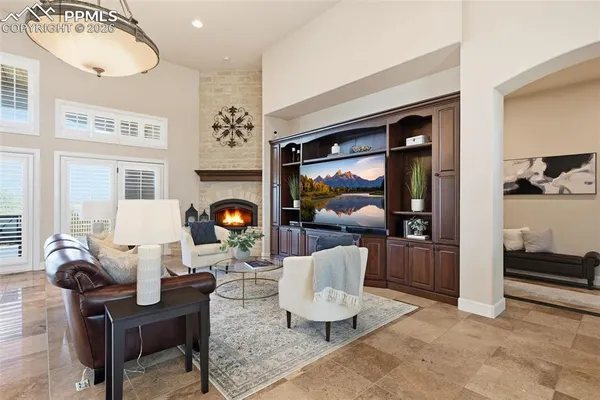 a living room with fireplace furniture and a large window
