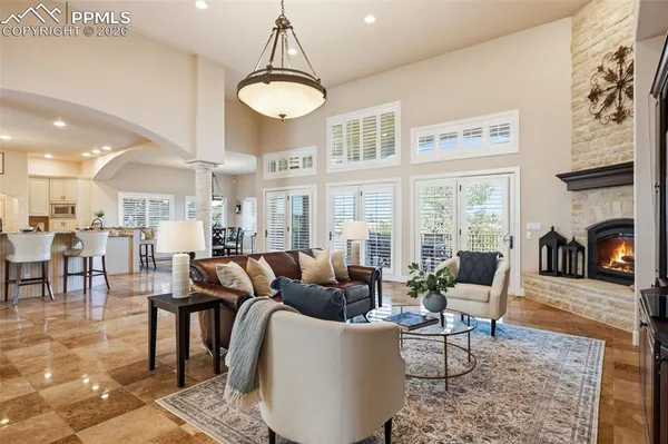 a living room with fireplace furniture and a large window