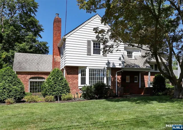 a front view of a house with a garden and yard