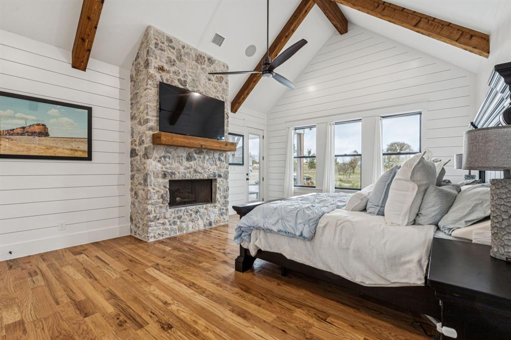 2577 Lone Star Road, Unit 1 Celina, TX 75009 - Photo 8 of 40 a spacious bedroom with a bed a fireplace and a flat tv screen