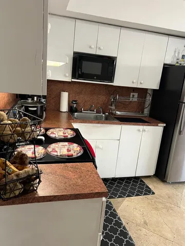 a kitchen with a sink a stove and a microwave