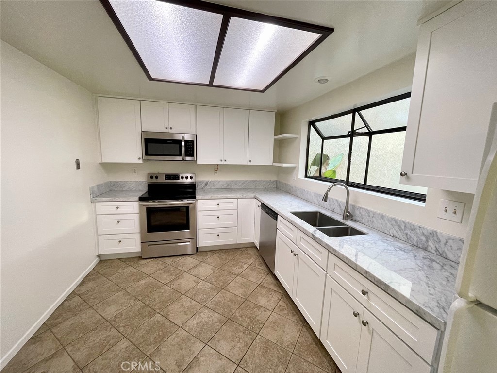 17 Grenache, Unit 72 Irvine, CA 92614 - Photo 11 of 20 a large kitchen with stainless steel appliances granite countertop a stove sink and cabinets