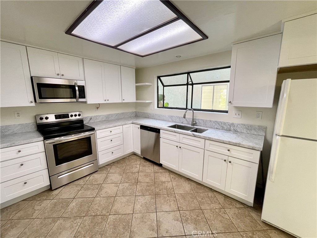17 Grenache, Unit 72 Irvine, CA 92614 - Photo 12 of 20 a kitchen with granite countertop a sink stainless steel appliances and white cabinets