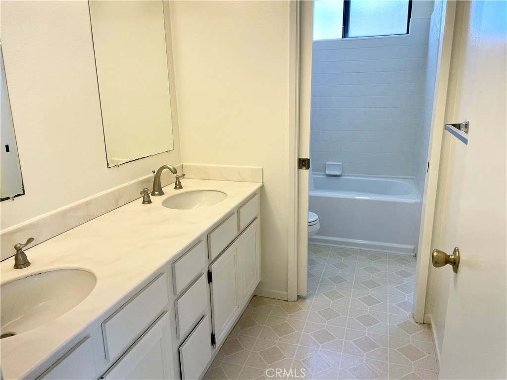 17 Grenache, Unit 72 Irvine, CA 92614 - Photo 17 of 20 a bathroom with a sink double vanity granite tub shower and a mirror