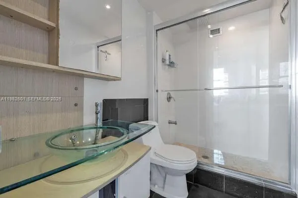 a bathroom with a sink toilet a mirror and shower