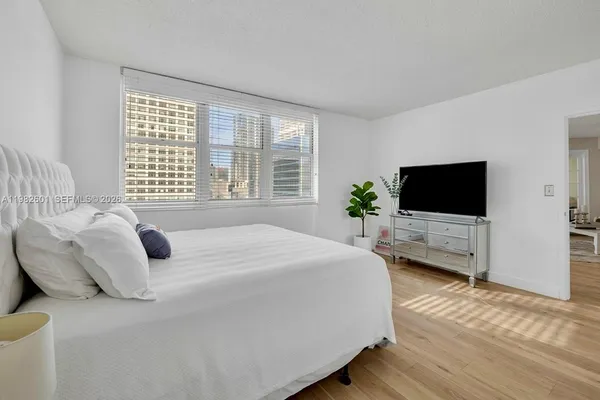 a bedroom with a bed outdoor view and a flat screen tv