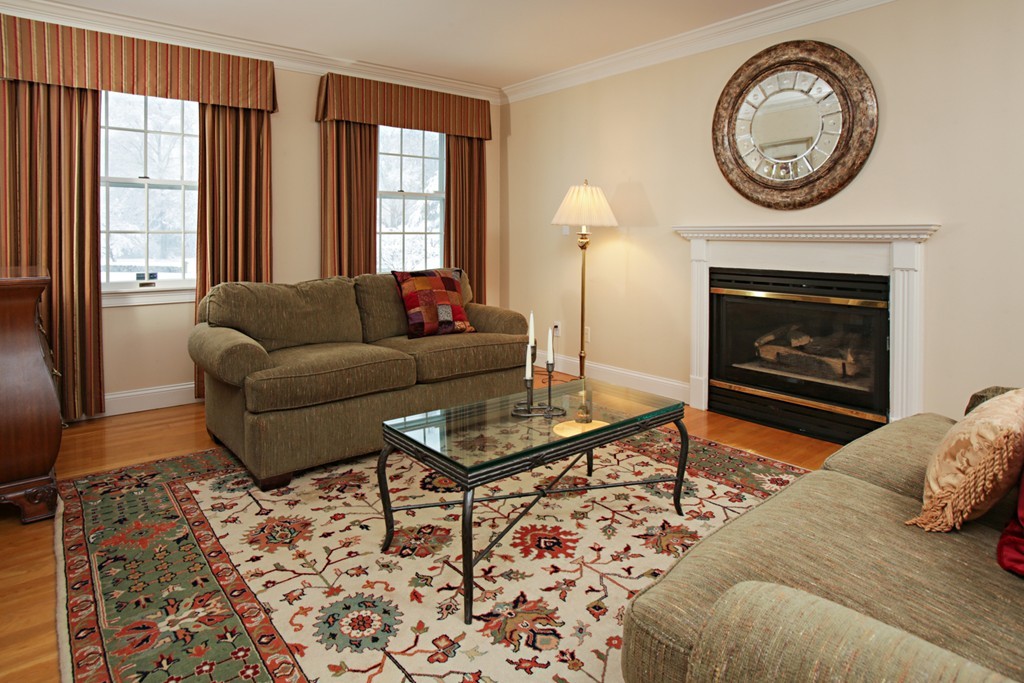 321 Concord Road Wayland, MA 01778 - Photo 2 of 12 a living room with furniture a clock and a fireplace