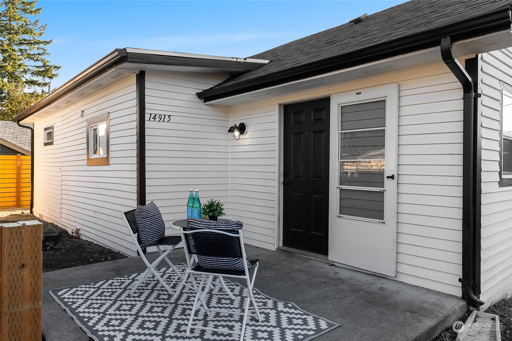 14915 Portland Avenue Southwest Lakewood, WA 98498 - Photo 1 of 24 a view of a patio with table and chairs and wooden fence