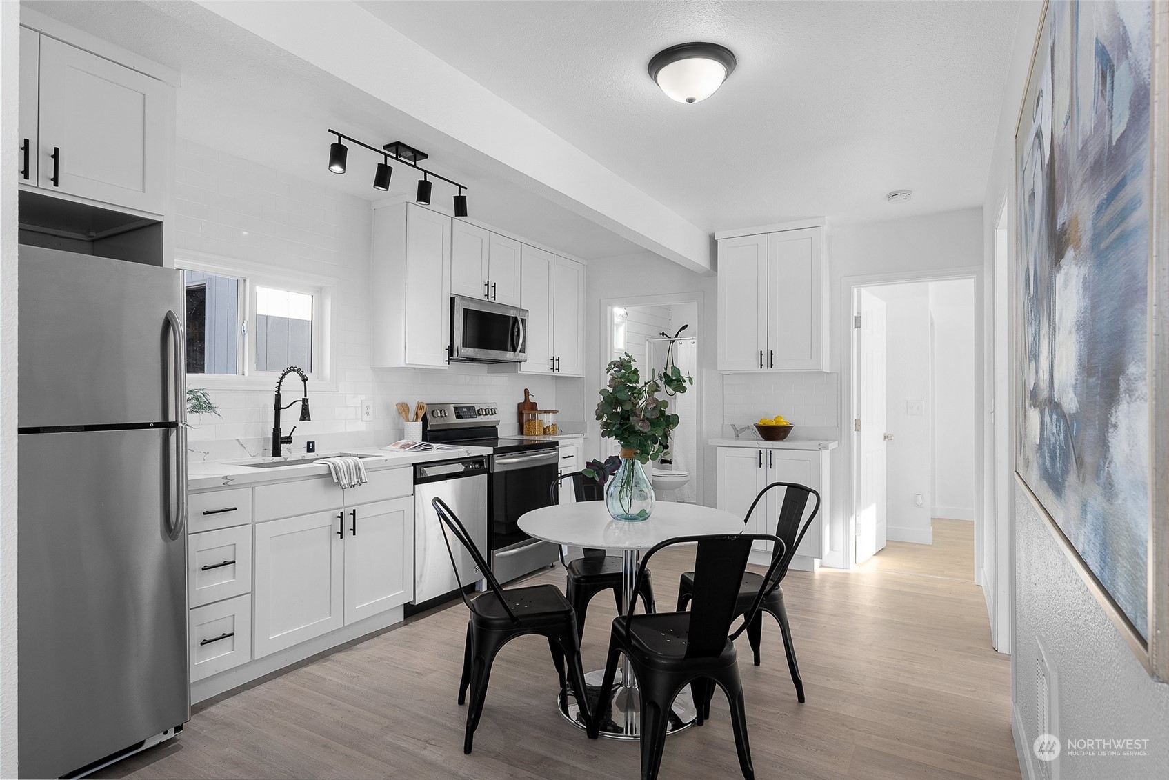 14915 Portland Avenue Southwest Lakewood, WA 98498 - Photo 5 of 24 a kitchen with stainless steel appliances a dining table chairs refrigerator and sink