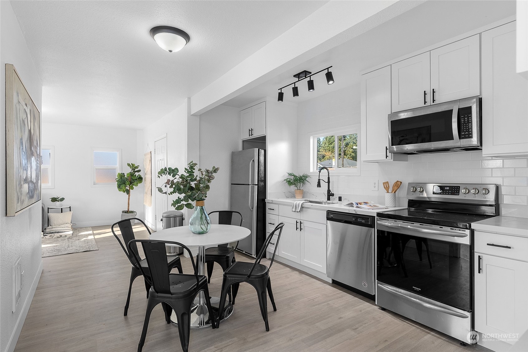 14915 Portland Avenue Southwest Lakewood, WA 98498 - Photo 6 of 24 a kitchen with stainless steel appliances a white table and chairs