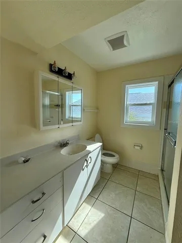 a spacious bathroom with a granite countertop sink a toilet and a mirror