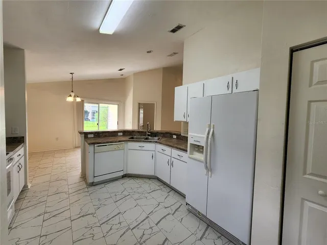a kitchen with granite countertop a stove sink and cabinets