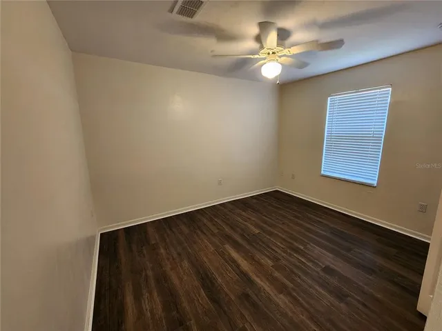 a view of an empty room with closet and a window
