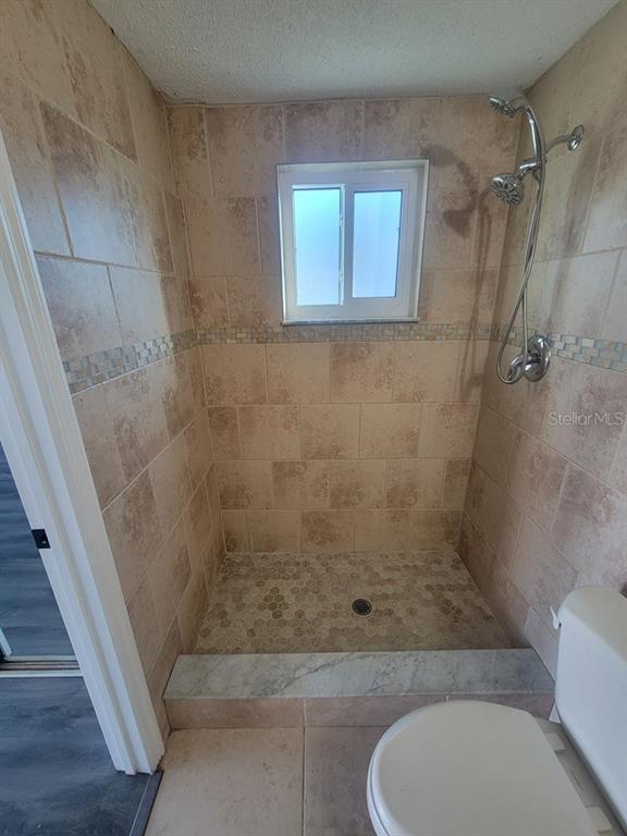 7741 Treasure Pointe Drive Port Richey, FL 34668 - Photo 17 of 20 a bathroom with a shower and toilet