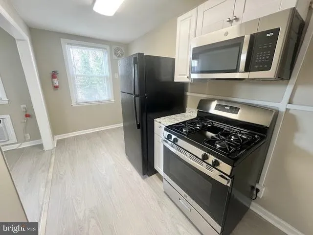 a kitchen with stainless steel appliances a stove a microwave and a refrigerator