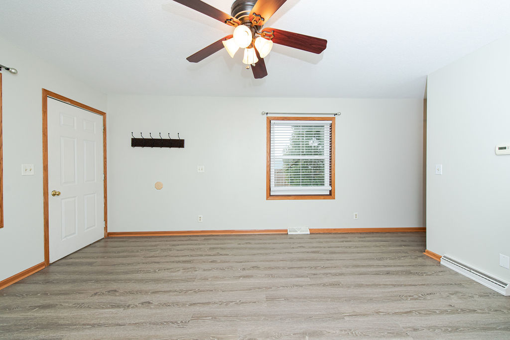 25696 Raska Lane, Unit A Lake Villa, IL 60046 - Photo 16 of 31 an empty room with wooden floor chandelier fan and windows