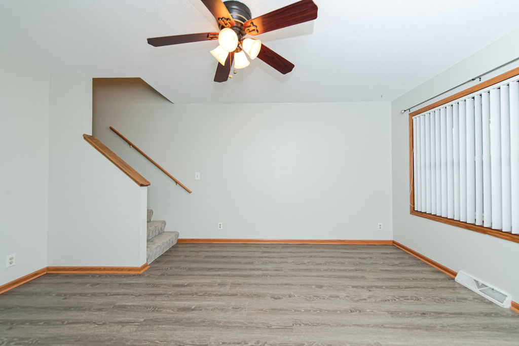 25696 Raska Lane, Unit A Lake Villa, IL 60046 - Photo 5 of 31 an empty room with wooden floor chandelier fan and windows