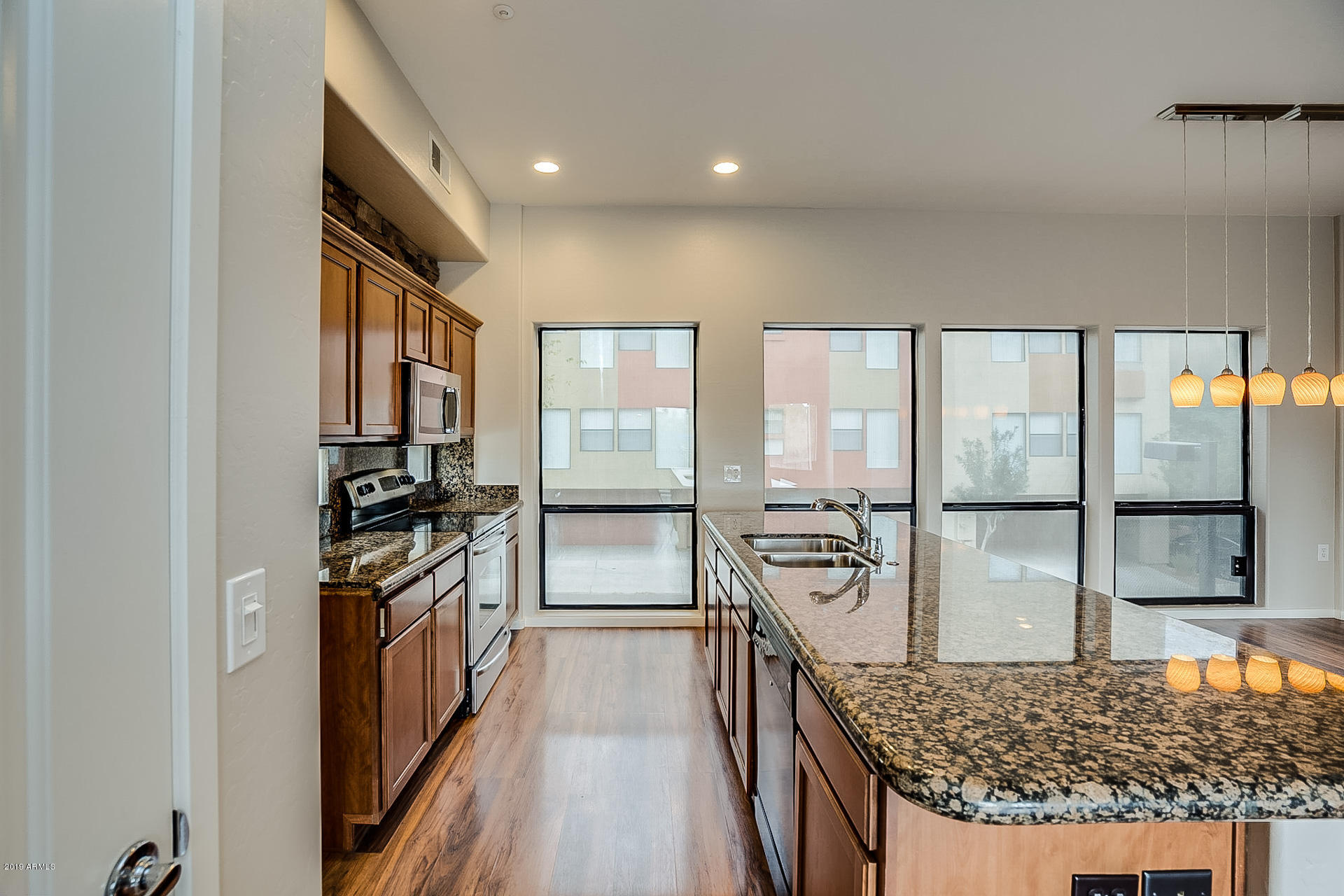 4746 East Culver Street Phoenix, AZ 85008 - Photo 6 of 13 a kitchen with stainless steel appliances granite countertop a stove oven and a refrigerator