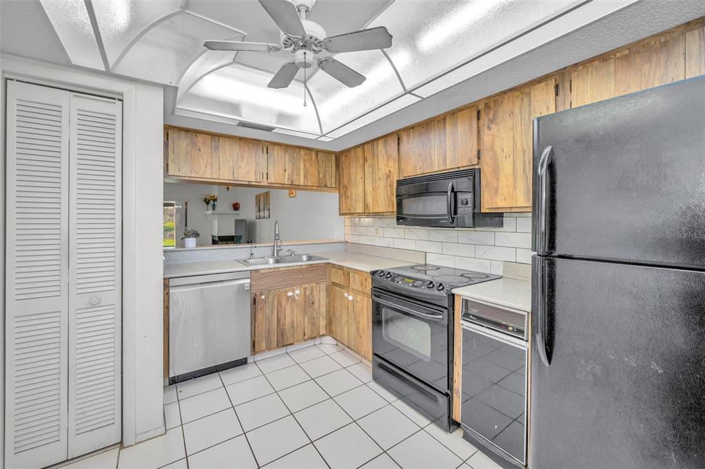 103 Lakeview Place, Unit 3 Oldsmar, FL 34677 - Photo 21 of 54 a kitchen with stainless steel appliances granite countertop a sink a stove a refrigerator a washer dryer and white cabinets