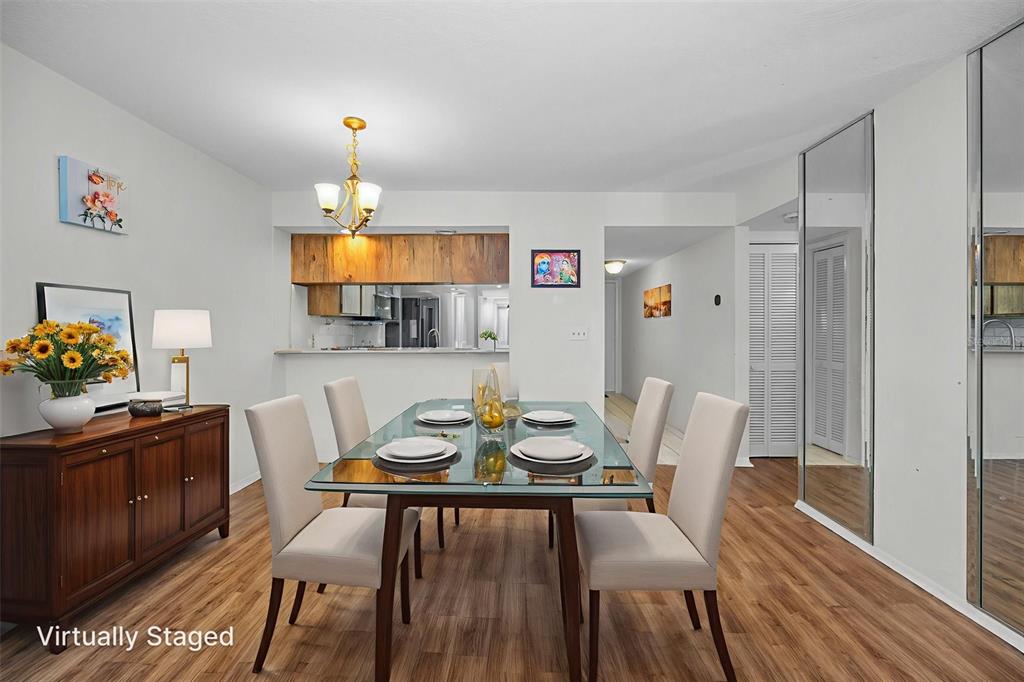103 Lakeview Place, Unit 3 Oldsmar, FL 34677 - Photo 10 of 54 a view of a dining room with furniture a chandelier and wooden floor