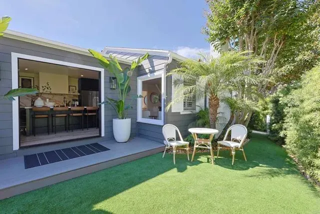 a view of a chair and table in backyard of the house