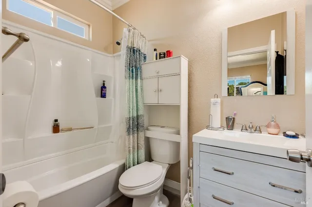 a bathroom with a sink toilet vanity and shower
