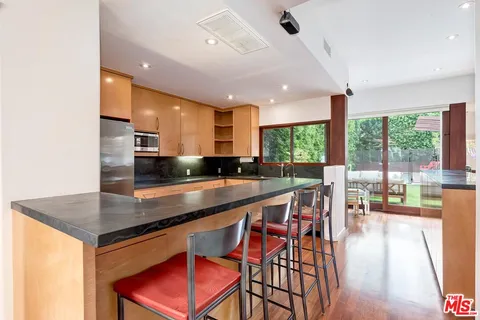 a kitchen with stainless steel appliances granite countertop a stove a sink and a refrigerator