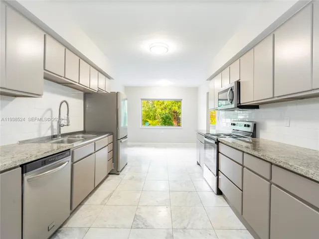 a kitchen with stainless steel appliances granite countertop a sink and cabinets