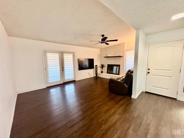 a view of a livingroom with furniture a ceiling fan and wooden floor