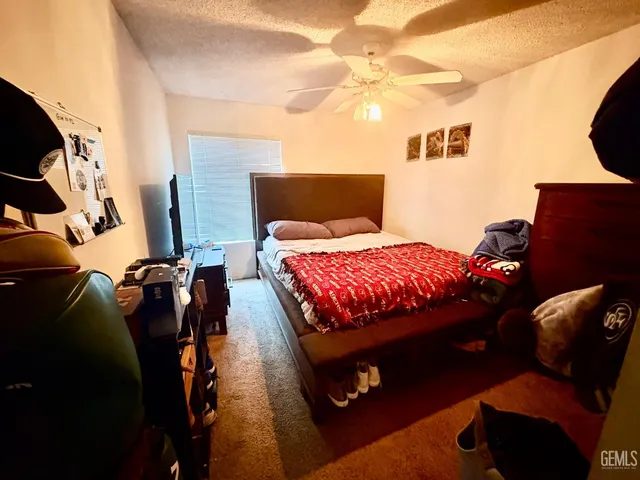 a bedroom with a bed and teddy bear on bed