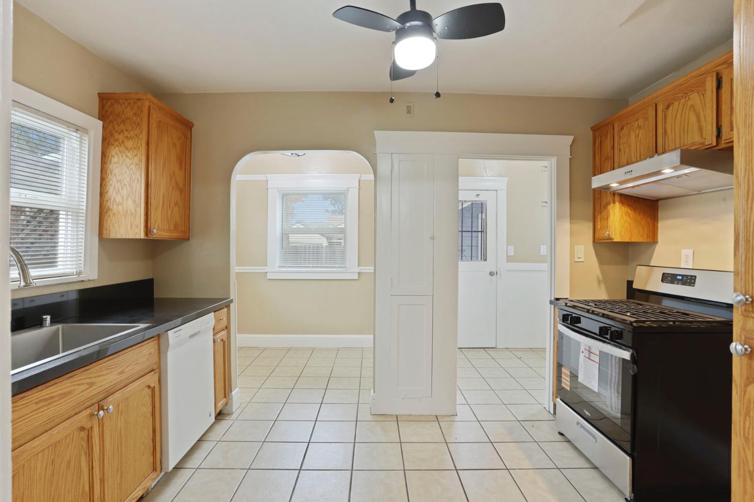 116 East Noble Street Stockton, CA 95204 - Photo 6 of 27 The updated kitchen with beautiful tiled floors, new granite countertops, new ceiling fan, new deep stainless steel sink and faucet, new stove and recirculating fan and light. Notice the moldings and wood painted details? Notice the dishwasher? You won't find a dishwasher in many of these classic homes.