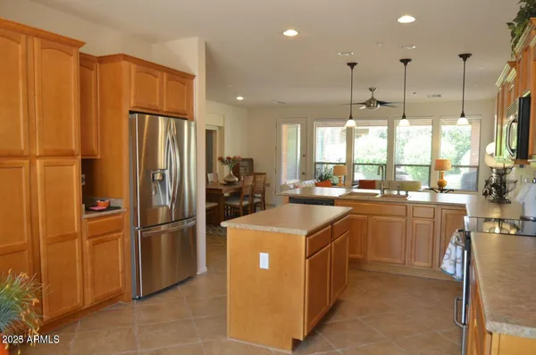 a kitchen with stainless steel appliances granite countertop a sink a stove and a refrigerator