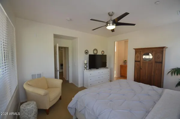 a bedroom with a bed window and a chandelier