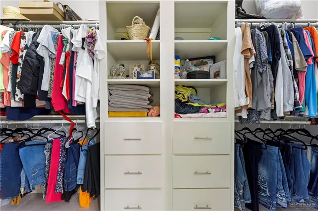 a view of walk in closet with clothes and shoes