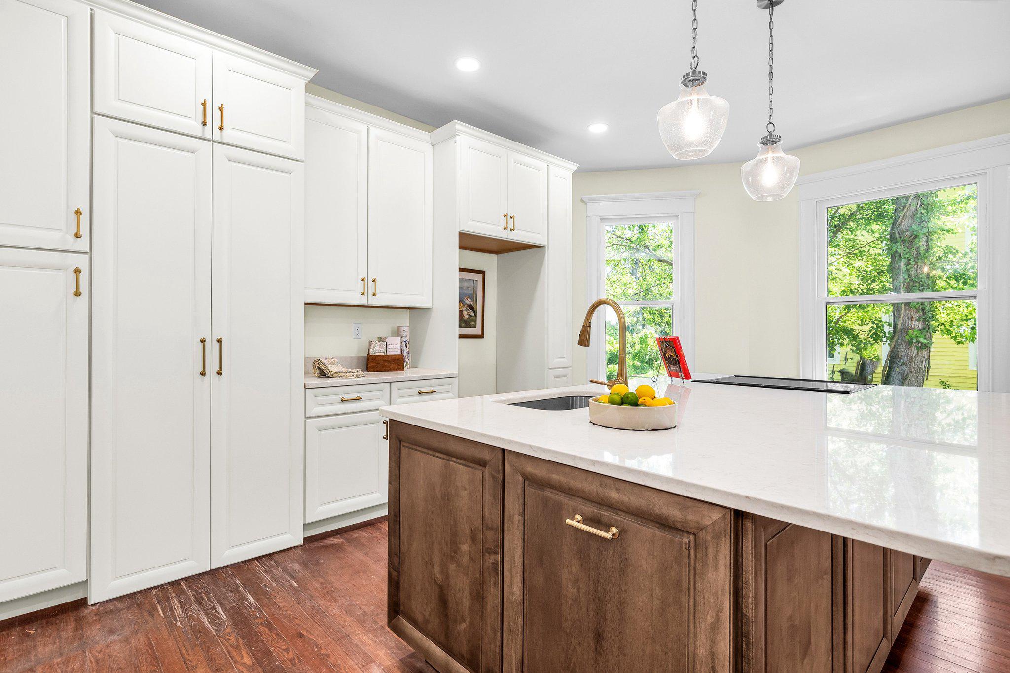 709 Church Street Cambridge, MD 21613 - Photo 14 of 36 a kitchen with kitchen island white cabinets appliances and a window