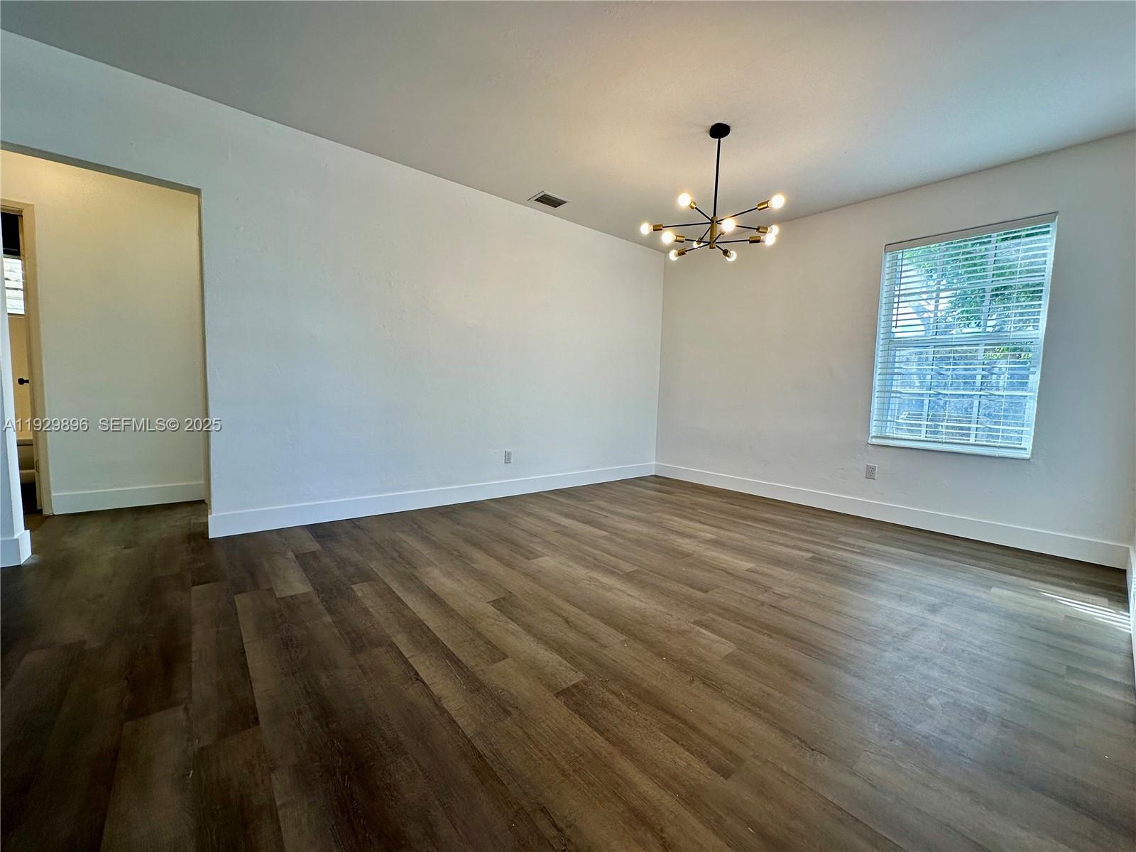 1788 Northeast 169th Street, Unit 1 North Miami Beach, FL 33162 - Photo 6 of 19 wooden floor in an empty room with a window