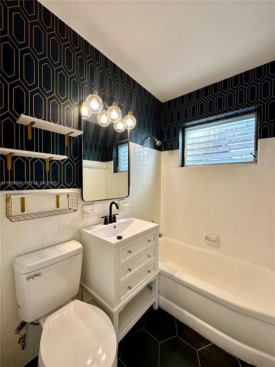 1788 Northeast 169th Street, Unit 1 North Miami Beach, FL 33162 - Photo 8 of 19 a bathroom with a sink a toilet and a bathtub