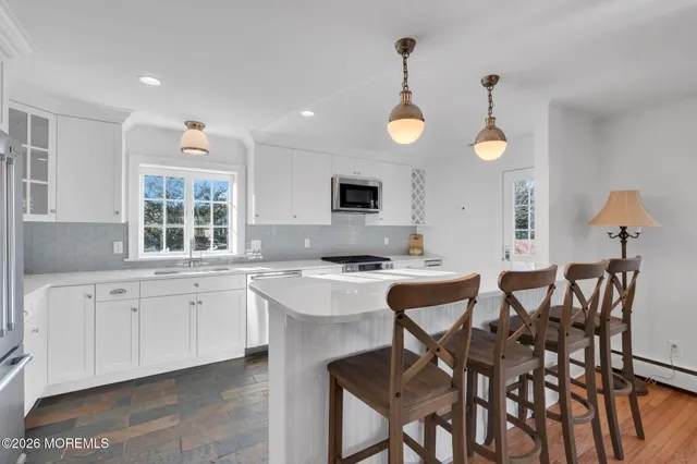a kitchen with cabinets a sink dining table and chairs