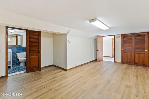 an empty room with wooden floor and closet