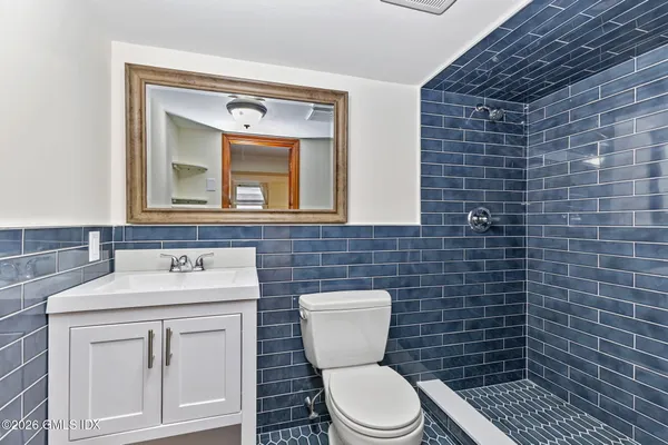 a bathroom with a toilet sink vanity and mirror