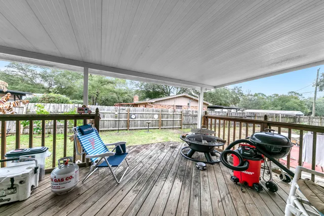 a view of a patio with table and chairs barbeque with wooden floor and fence
