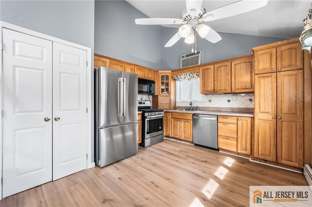 67 Drake Place Colonia, NJ 07067 - Photo 6 of 31 a kitchen with stainless steel appliances granite countertop a refrigerator a sink dishwasher a stove with white cabinets and wooden floor