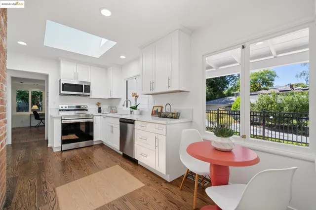a kitchen with granite countertop a stove a sink a dining table and chairs