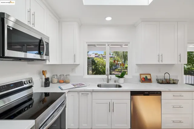 a kitchen with stainless steel appliances white cabinets and a stove top oven